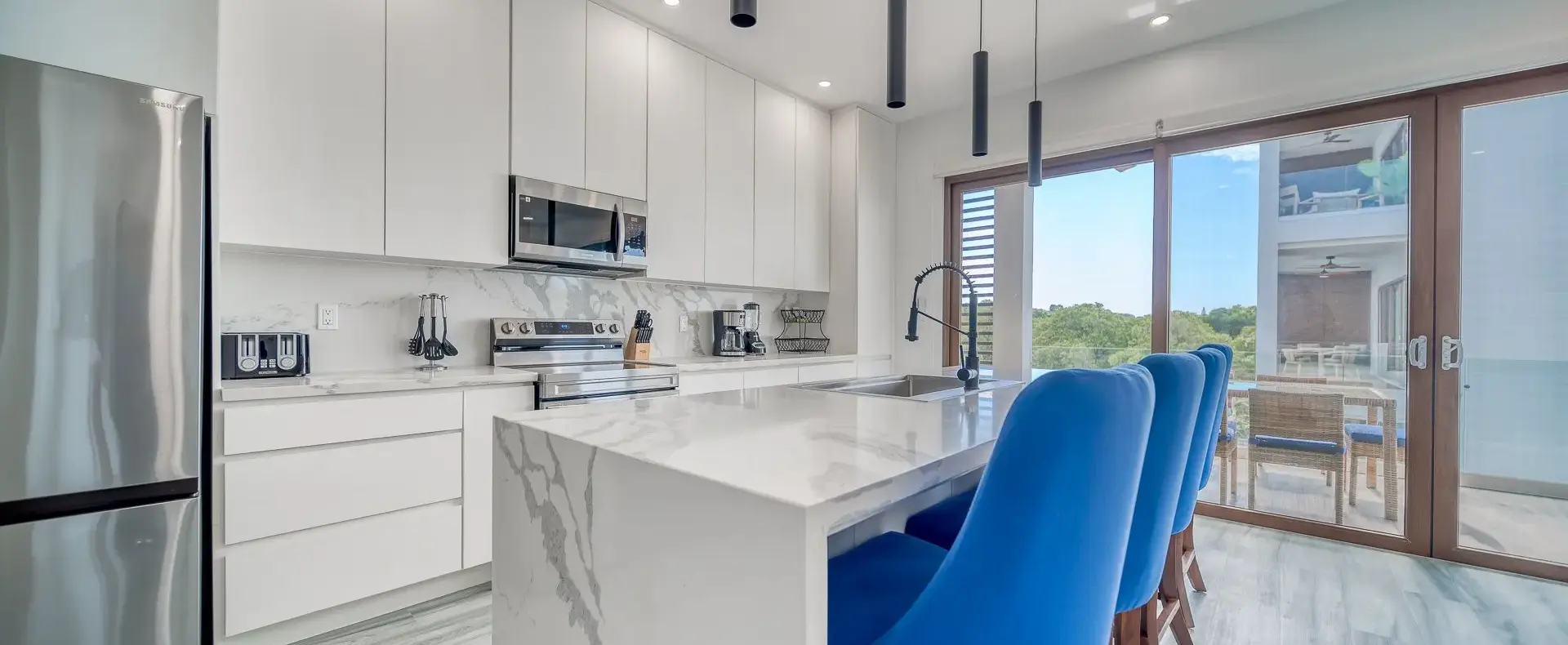 Kitchen with marble island and blue stools, Acqua di Mare condo