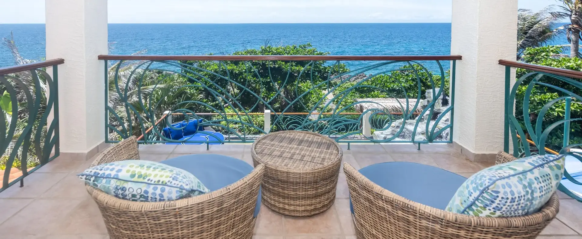 Covered balcony with wicker chairs overlooking the sea, Lighthouse Estates