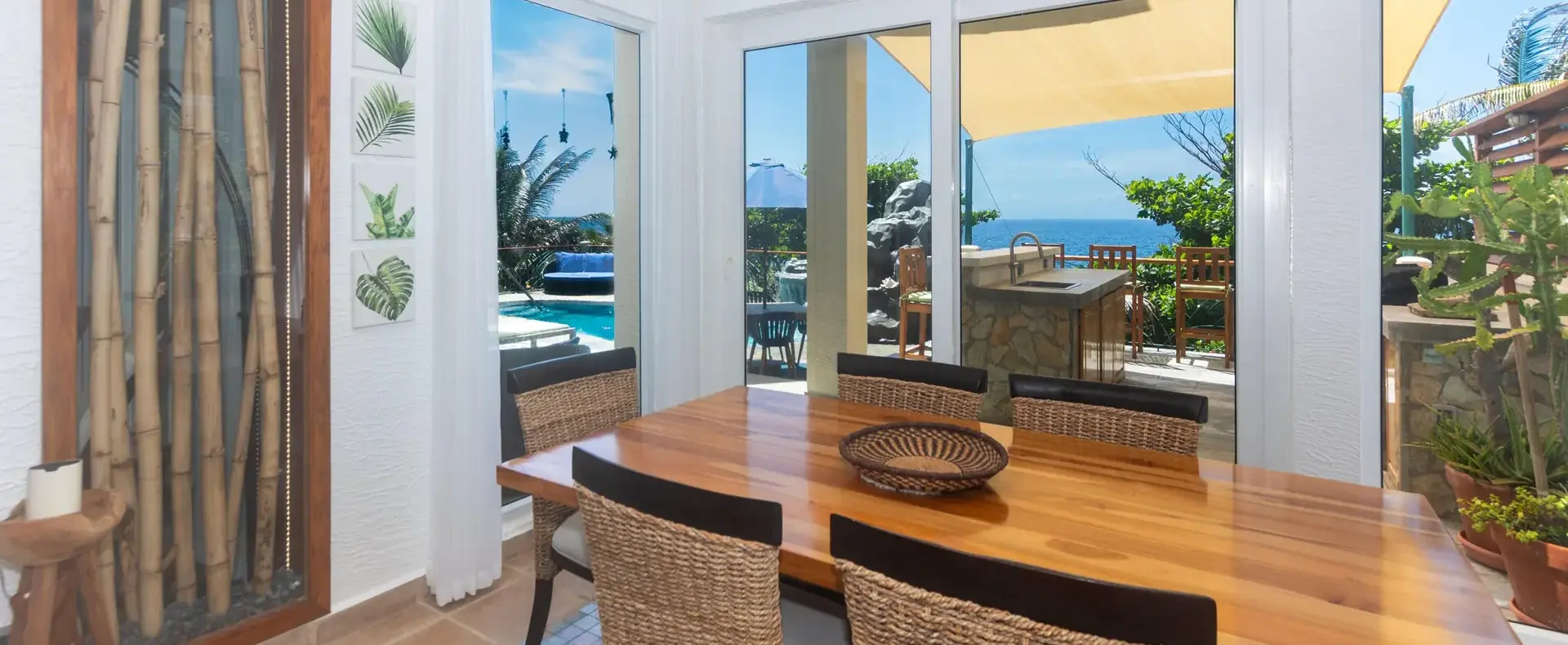 Dining room with wooden table and sliding doors to the pool terrace