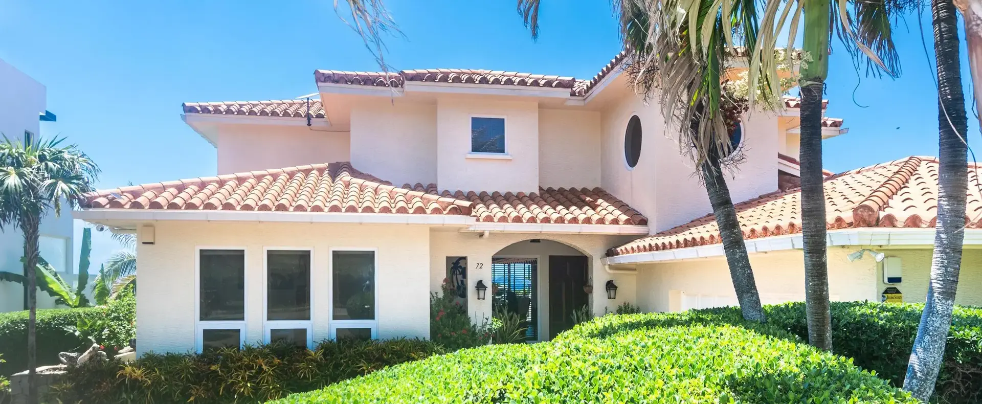 Front of Casa Cascada with tropical landscaping and tile roof