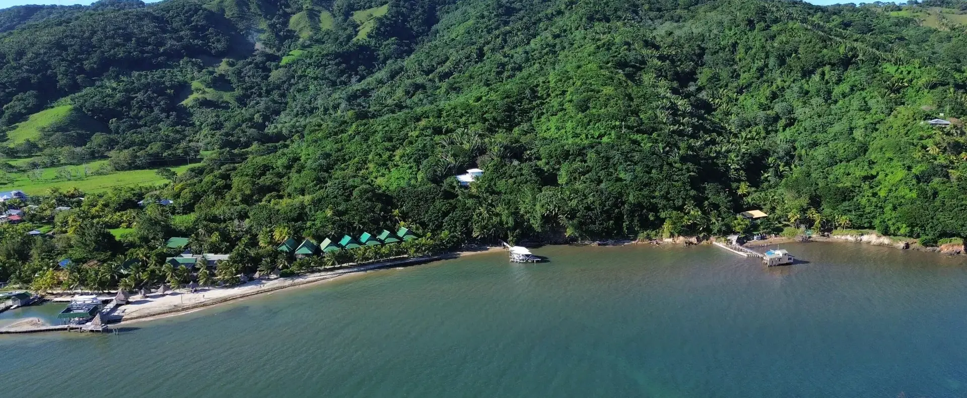 Calm bay with docks and forested mountains in Guanaja
