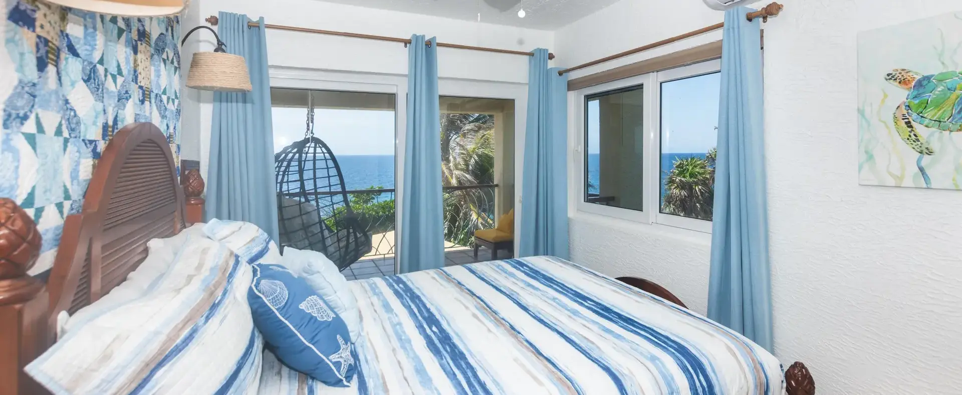 Upstairs guest bedroom with blue decor and balcony access