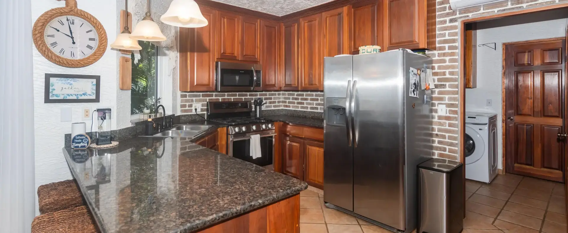 Kitchen with granite countertops and stainless-steel refrigerator