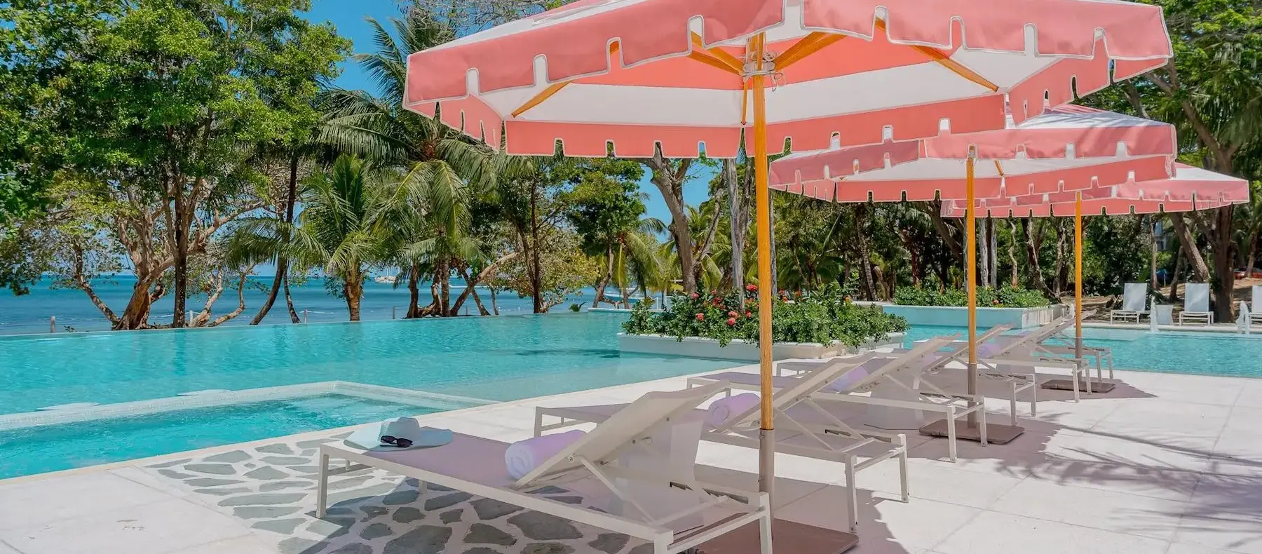 Pool deck with loungers and umbrellas next to the ocean