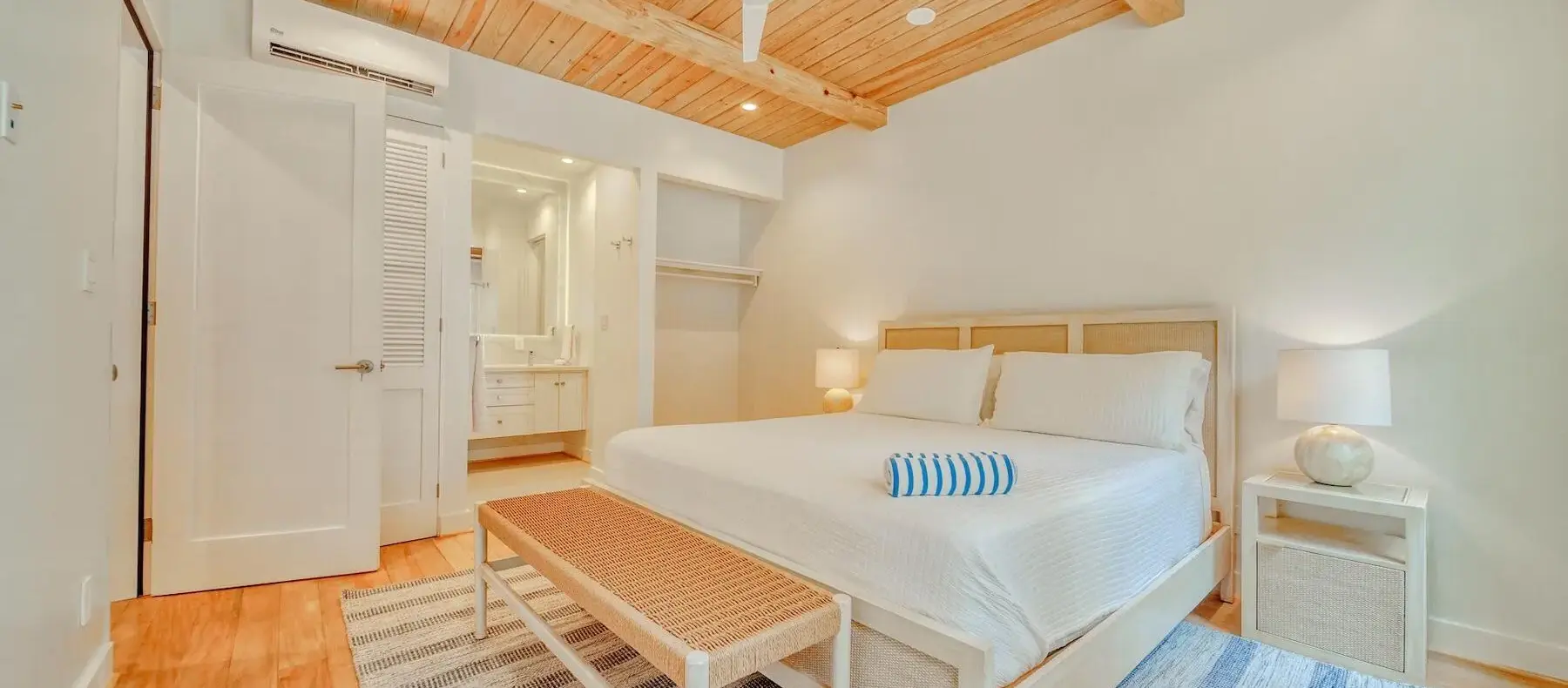 Primary bedroom with wood-beam ceiling (sample unit)